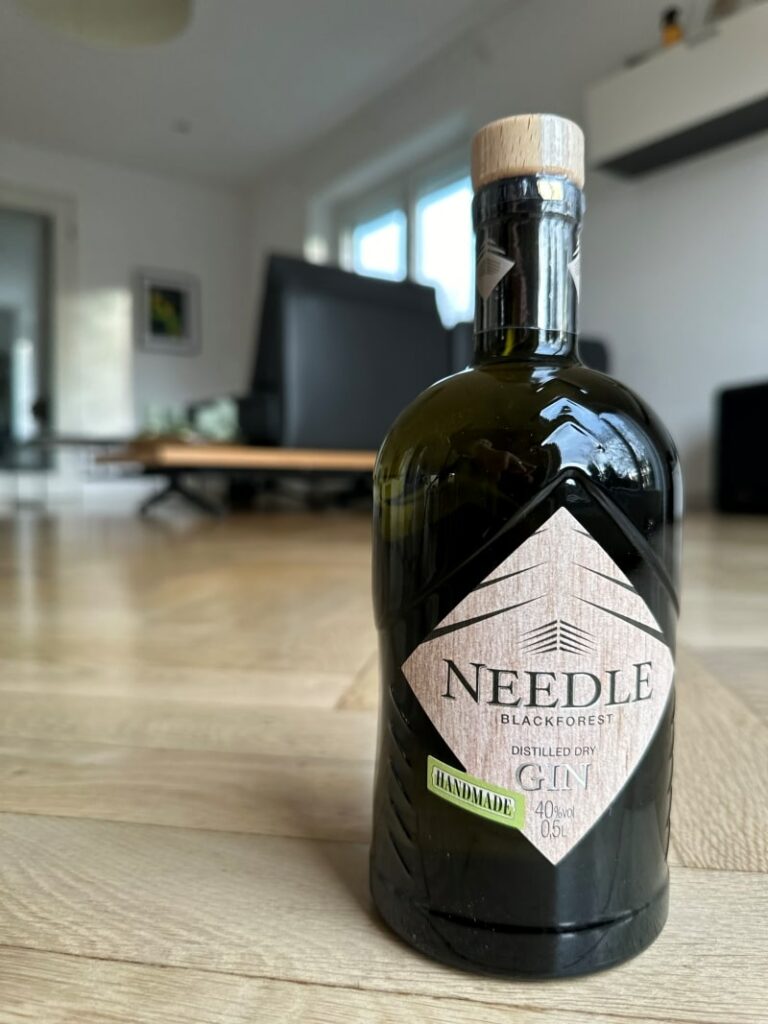 Needle Black Forest Distilled Dry Gin - Ein Wald voller Aromen 1 Eine Flasche Needle Black Forest Distilled Dry Gin steht in einem Wohnzimmer.