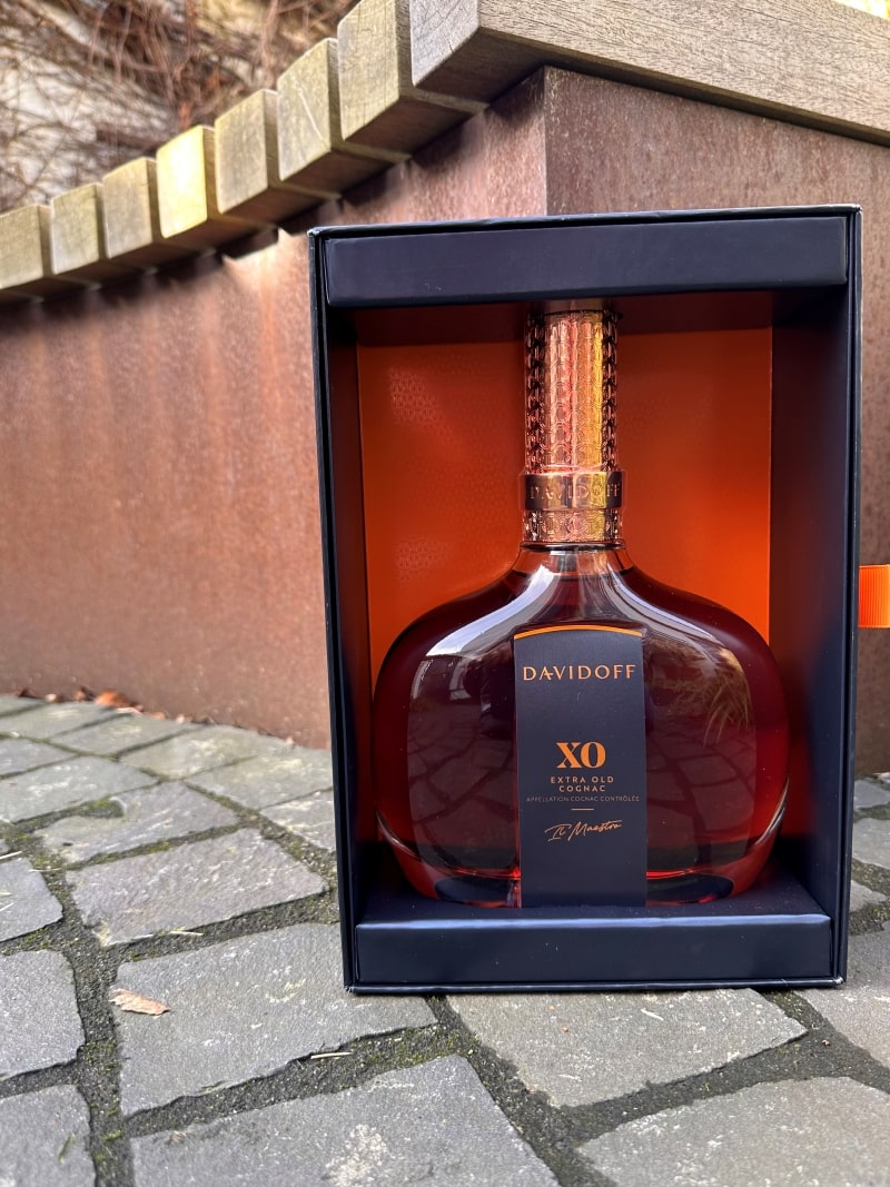 Davidoff XO Cognac - Aromen Explosion 8 Eine Flasche Davidoff XO Cognac vor einer Bank.