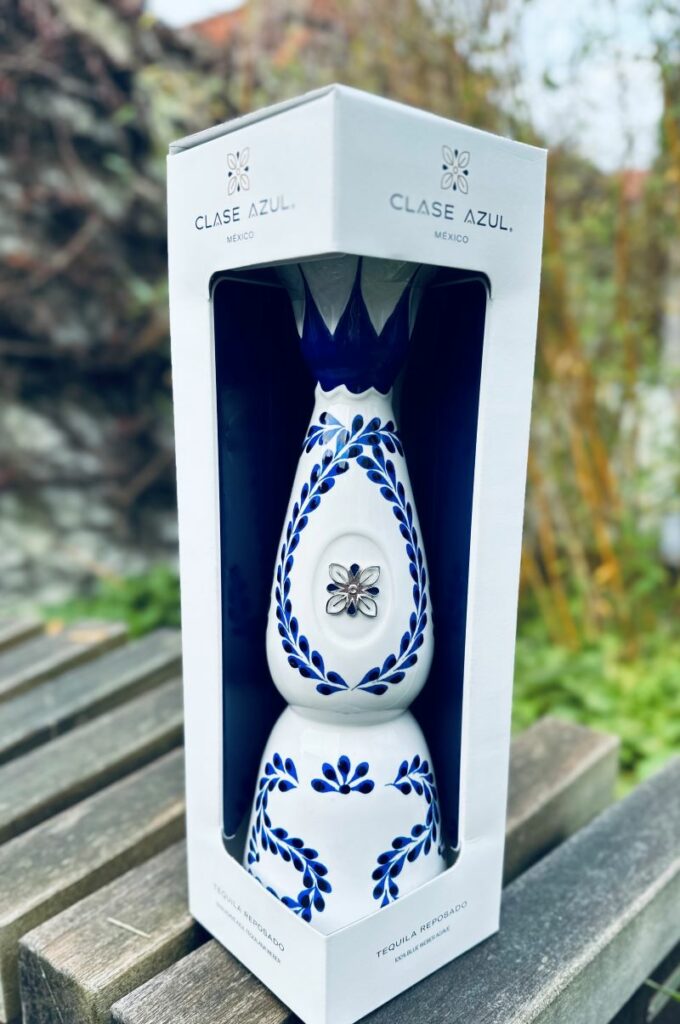 Don Julio 70 Tequila - Entdecke die Magie 10 Eine Flasche Clase Azul Reposado in Geschenkverpackung in einem Garten.