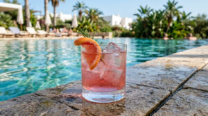 Drinksmeister 1 Ein Glas Pink Negroni am Pool.